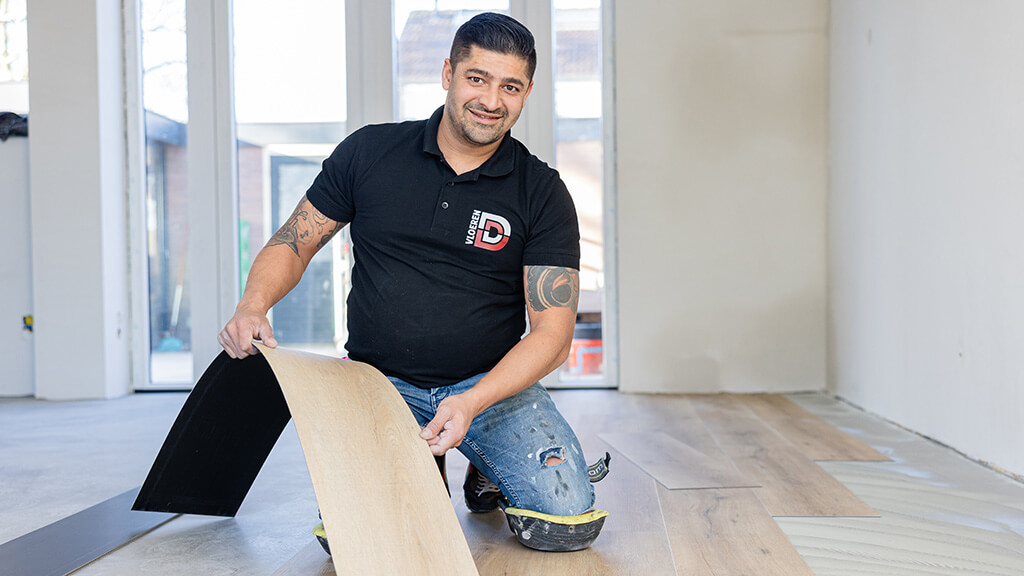 Installateur legt brede planken pvc houtlook vloer in woonkamer