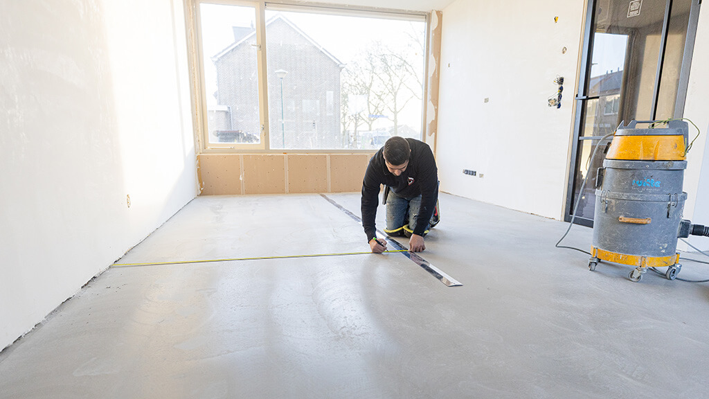 Vakman legt een rigid click pvc vloer zonder egalisatie